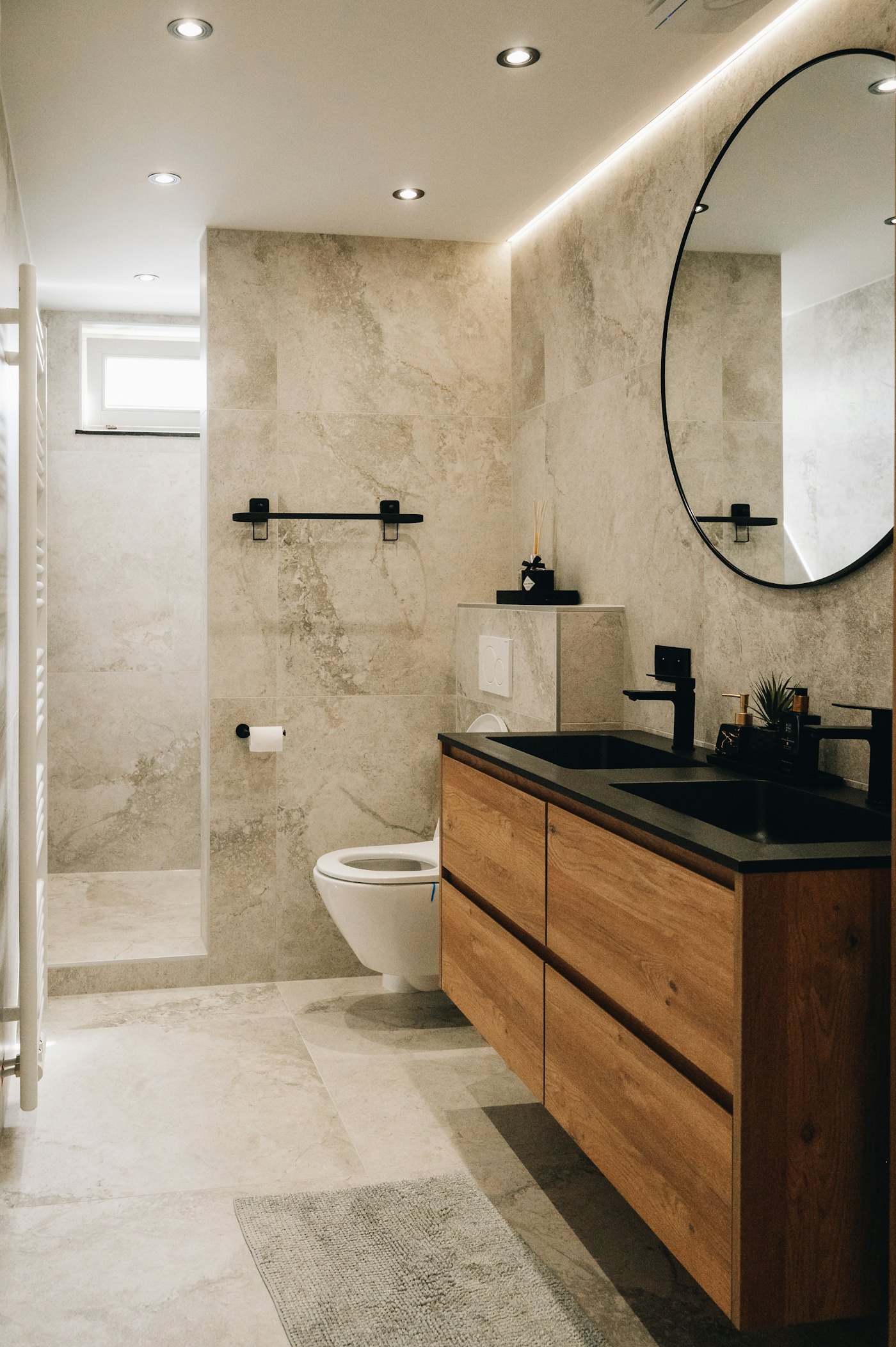 Paddington ensuite with a full-height mirror above a wall-hung vanity and fluted timber joinery.