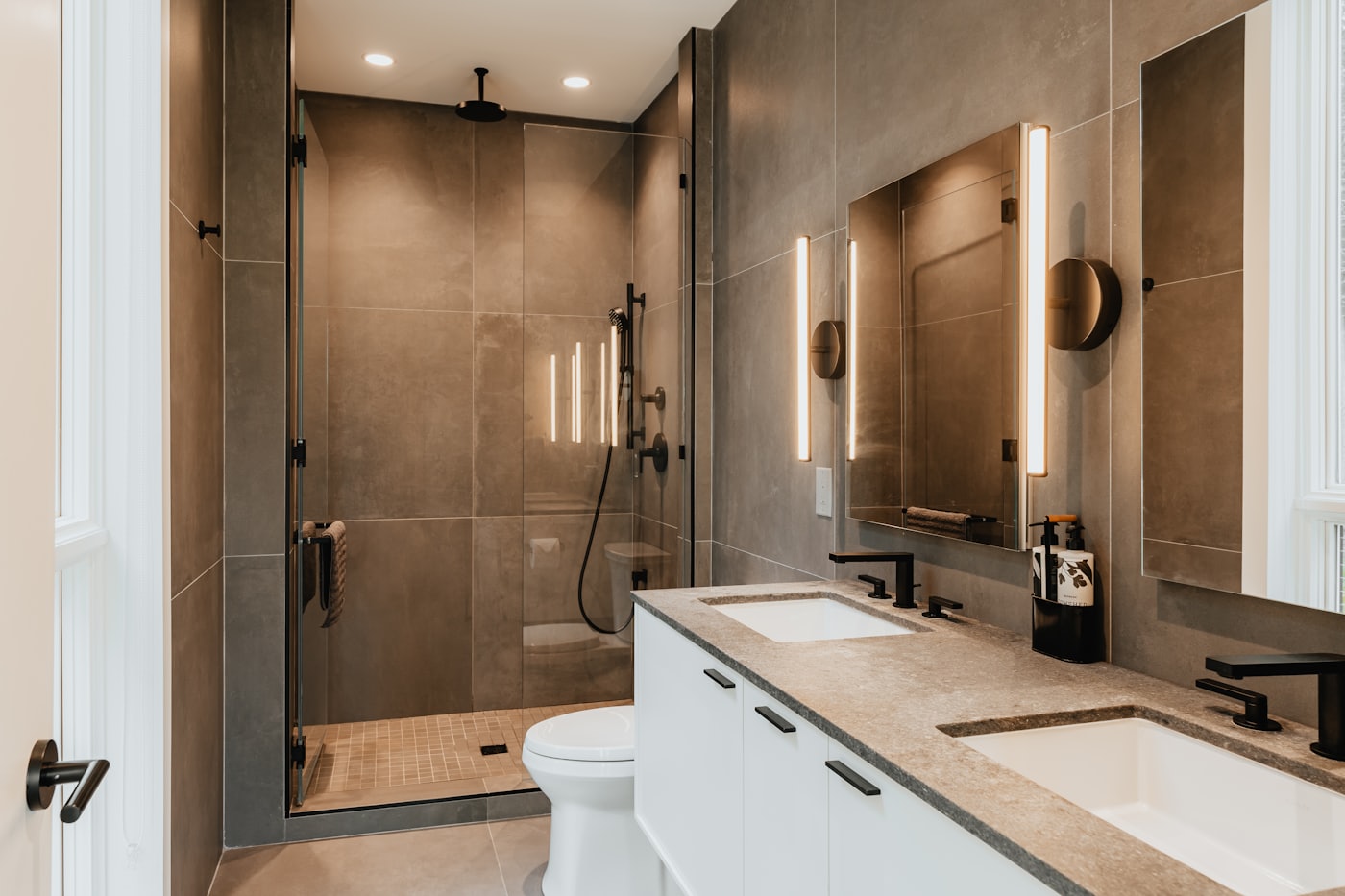Manly family bathroom with two basins, a toilet and a walk-in shower.
